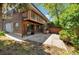 Two-story home featuring wood and brick, a concrete patio, and a walkout balcony overlooking lush landscaping at 12771 W 6Th Pl, Lakewood, CO 80401