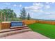 Backyard features a hot tub, artificial grass, and wooden fence at 40192 Margaret Dr, Elizabeth, CO 80107