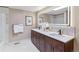 Bright bathroom featuring dual sinks, white countertops, and a large mirror at 40192 Margaret Dr, Elizabeth, CO 80107