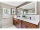Modern bathroom with dual sinks, wood vanity, and an oversized backlit mirror at 40192 Margaret Dr, Elizabeth, CO 80107