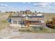 Split level home with two car garage, wooden deck and stairs with farm buildings in background at 40192 Margaret Dr, Elizabeth, CO 80107