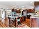 Spacious kitchen featuring a large island, hardwood floors, dark wood cabinetry, and stone countertops at 40192 Margaret Dr, Elizabeth, CO 80107