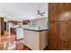 Open kitchen featuring hardwood floors, custom wood cabinetry, and breakfast bar open to dining space at 40192 Margaret Dr, Elizabeth, CO 80107