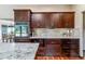 Well-equipped kitchen with granite countertops, dark wood cabinetry, built-in appliances, and hardwood floors at 40192 Margaret Dr, Elizabeth, CO 80107
