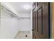 Spacious walk-in closet with white walls, carpet flooring, overhead light, shelving, and brown door at 40192 Margaret Dr, Elizabeth, CO 80107