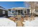 Cute bungalow with a snowy front yard and inviting front porch at 4855 Knox Ct, Denver, CO 80221