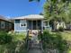 Charming bungalow with blue siding, mature trees, and a well-maintained lawn at 4855 Knox Ct, Denver, CO 80221