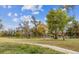 Park with large trees, green space, and play structures under a blue sky with clouds at 4855 Knox Ct, Denver, CO 80221