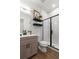 Modern bathroom with walk-in shower, floating shelves, and wood vanity at 2121 Hummingbird Way # 203, Georgetown, CO 80444