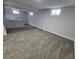 Finished basement space featuring new carpet, kitchenette with modern countertop, and natural light from egress windows at 8947 Rutgers St, Westminster, CO 80031