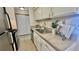 Galley-style kitchen with white cabinets and modern stainless steel appliances at 7695 E Quincy Ave # 207, Denver, CO 80237