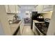 Kitchen leading to cozy dining area, black appliances and tile flooring at 7695 E Quincy Ave # 207, Denver, CO 80237