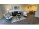 Open-concept living area with modern sofa, chairs, and dining area at 7695 E Quincy Ave # 207, Denver, CO 80237