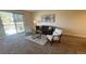 Bright living room with sliding glass doors to balcony and modern furniture at 7695 E Quincy Ave # 207, Denver, CO 80237