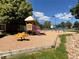 Community playground featuring a slide, swings, and a fun spring rider on a mulch surface at 5550 W 80Th Pl # 20, Arvada, CO 80003