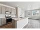 Modern kitchen features grey cabinets, quartz counters, stainless appliances and an island with seating at 14145 Deertrack Ln, Parker, CO 80134