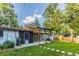 Expansive backyard features a patio area, lush lawn, and convenient storage sheds, perfect for Gathering fun at 7650 W 24Th Ave, Lakewood, CO 80214