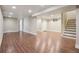 Open basement area with wood-look tile flooring, recessed lighting, and a staircase at 7650 W 24Th Ave, Lakewood, CO 80214