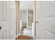 Hallway view into a well-lit bathroom featuring a tub, glass shower and modern finishes at 7650 W 24Th Ave, Lakewood, CO 80214