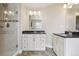 Elegant bathroom featuring double vanity sinks, granite countertops and a tiled shower at 7650 W 24Th Ave, Lakewood, CO 80214
