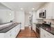 Galley kitchen features stainless steel appliances, white cabinets, and beautiful hardwood flooring at 7650 W 24Th Ave, Lakewood, CO 80214
