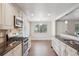 Bright and airy kitchen with stainless steel appliances, white cabinets, and hardwood floors at 7650 W 24Th Ave, Lakewood, CO 80214