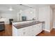 Open concept kitchen with an eat-in island, stainless steel sink, and view of the living room at 7650 W 24Th Ave, Lakewood, CO 80214