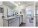 Bright bathroom featuring a dual-sink vanity with granite countertops and access to the bedroom at 4204 Sandstone Dr, Mead, CO 80504