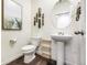 Powder room with pedestal sink, decorative mirror, and unique decor elements at 4204 Sandstone Dr, Mead, CO 80504