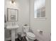 Clean and modern bathroom with pedestal sink, toilet and dark tile floor at 1867 W 137Th Ln, Broomfield, CO 80023