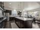 Modern kitchen featuring dark cabinets, stainless steel appliances, a large center island, and an adjacent dining area at 1867 W 137Th Ln, Broomfield, CO 80023