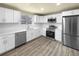 Modern kitchen with white cabinets, stainless steel appliances, and quartz countertops at 10547 Pompey Way, Northglenn, CO 80234
