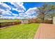 Backyard featuring green grass, deck, shed, and fenced perimeter at 10704 Moore St, Broomfield, CO 80021