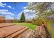 Backyard with deck, green grass, shed, and gravel area with brick borders at 10704 Moore St, Broomfield, CO 80021