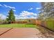 Backyard featuring green grass, deck, shed, and fenced perimeter at 10704 Moore St, Broomfield, CO 80021