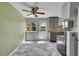 Open kitchen with marble floors, gray cabinets, stainless steel appliances, and a ceiling fan at 10704 Moore St, Broomfield, CO 80021