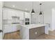 Bright kitchen featuring wood flooring, island, white cabinets, and modern stainless steel appliances at 4331 Soapberry Pl, Castle Rock, CO 80108