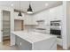 Bright kitchen featuring a quartz waterfall island, stainless steel appliances, and modern white cabinets at 4331 Soapberry Pl, Castle Rock, CO 80108