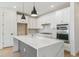 Modern kitchen featuring a quartz waterfall island, stainless steel appliances, and sleek white cabinetry at 4331 Soapberry Pl, Castle Rock, CO 80108