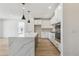 Open kitchen with a quartz waterfall island, stainless steel appliances, and hardwood floors at 4331 Soapberry Pl, Castle Rock, CO 80108