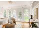 Bright sunroom featuring arched windows, hardwood floors, and comfortable seating at 4224 N Clay St, Denver, CO 80211
