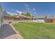 Large grassy backyard with a cement retaining wall and a wooden fence at 16149 E Rice Pl # A, Aurora, CO 80015