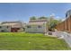 Green townhouse backyard with a low cement retaining wall, grass, and wood fence at 16149 E Rice Pl # A, Aurora, CO 80015