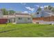 Townhouse backyard with green vinyl siding, lush grass, and a stone retaining wall at 16149 E Rice Pl # A, Aurora, CO 80015