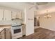 Well-equipped kitchen with white appliances, wood-look flooring, and an adjacent dining area at 16149 E Rice Pl # A, Aurora, CO 80015