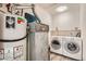 Well-equipped laundry room with modern washer, dryer, and efficient water heater at 16149 E Rice Pl # A, Aurora, CO 80015