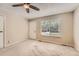 Inviting room features neutral walls and carpet, a ceiling fan, and a large window for natural light at 16149 E Rice Pl # A, Aurora, CO 80015