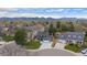 Aerial view of a home showcasing its landscaped yard, mature trees, and mountain views at 9391 W Hialeah Pl, Littleton, CO 80123