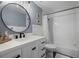 Bathroom with a round mirror, modern vanity with black accents, and a tub with white subway tiles at 9391 W Hialeah Pl, Littleton, CO 80123