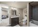 Bathroom showcasing a dark wood vanity, a tiled shower, and open access to another room at 9391 W Hialeah Pl, Littleton, CO 80123